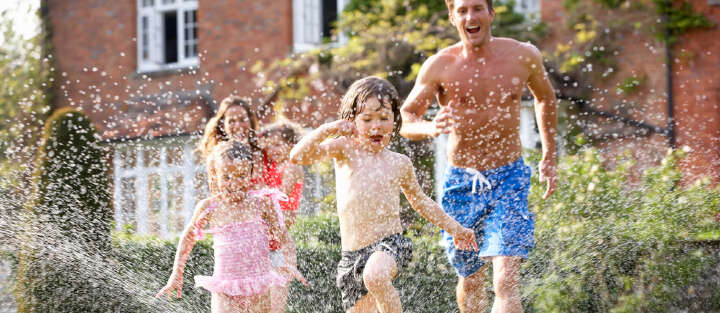 familie im garten rennt unterm wasser spaß 1700x740